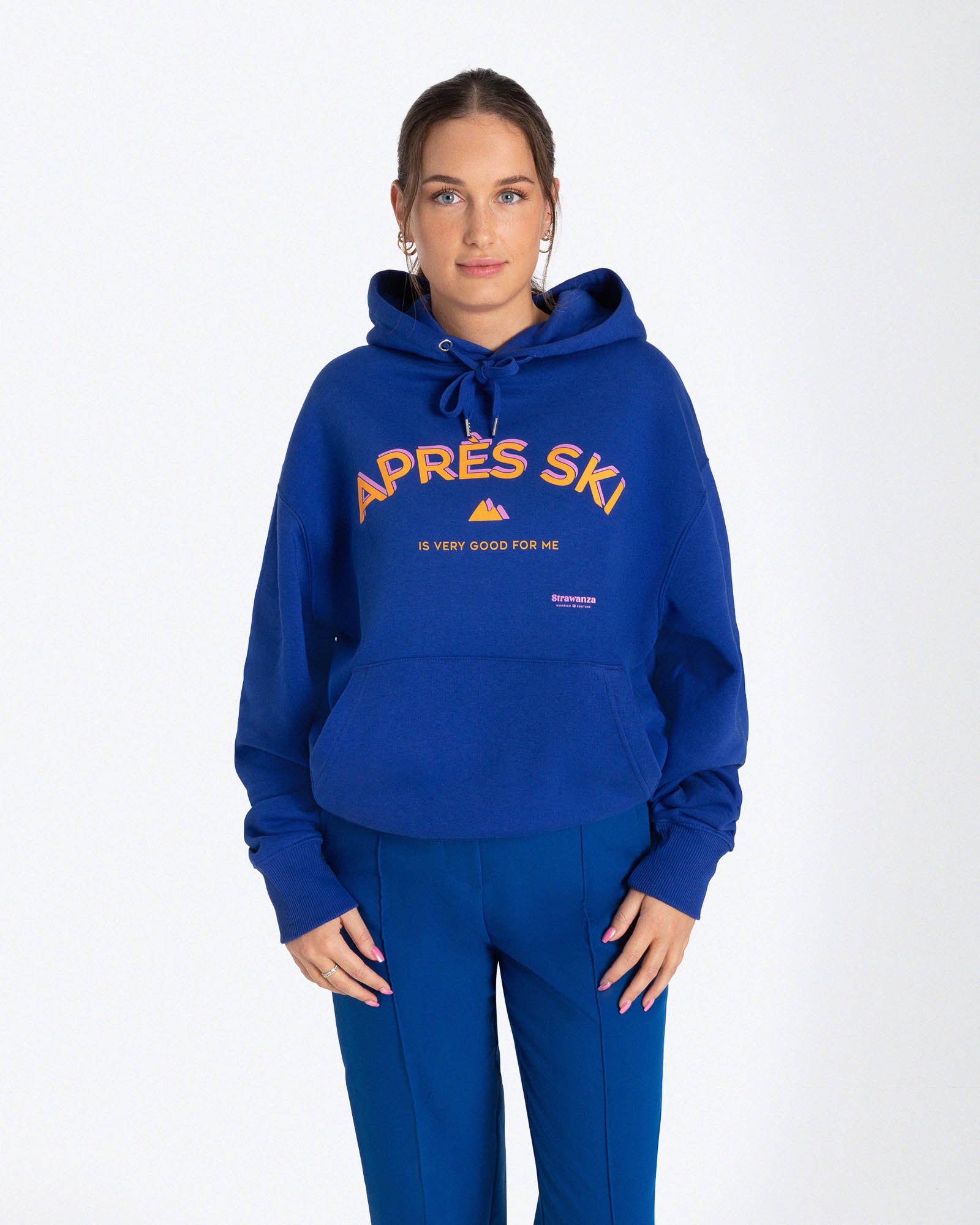 Entdecken Sie den stylischen 'APRES SKI HOODIE' von Strawanza, ideal für Outdoor-Abenteuer. Das Model präsentiert diesen trendigen blauen Hoodie in einer natürlichen Kulisse, die Funktionalität und Modebewusstsein vereint. Der Hoodie zeichnet sich durch sein starkes blau und den Siebdruck im Retro Stil aus. Perfekt für Berg- und Skiabenteuer. Hier am Model zu sehen